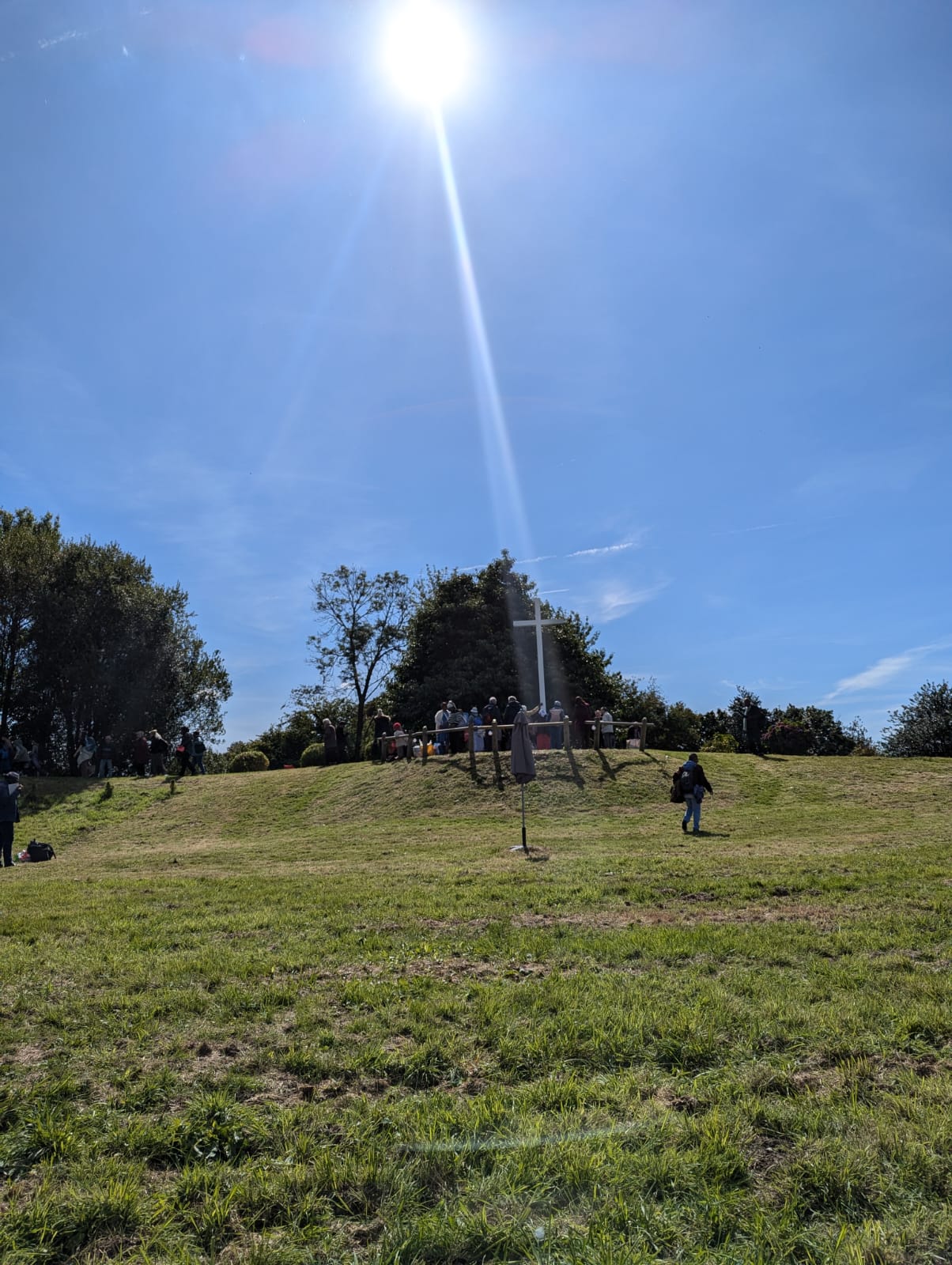Parc ensoleillé avec personnes et colline verdoyante